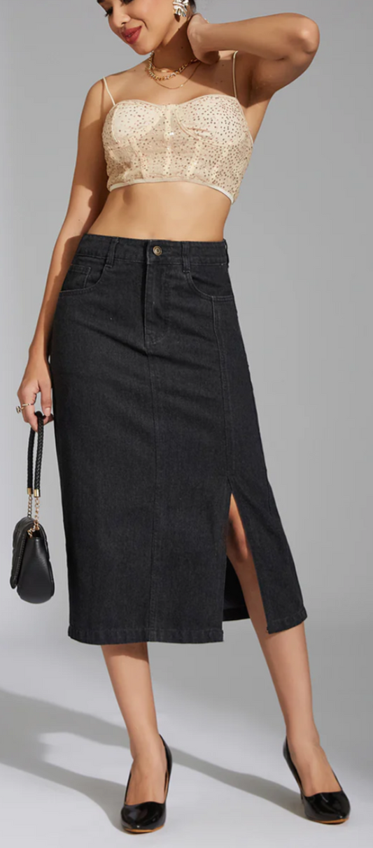 Woman wearing a beige top and black skirt on a gray background