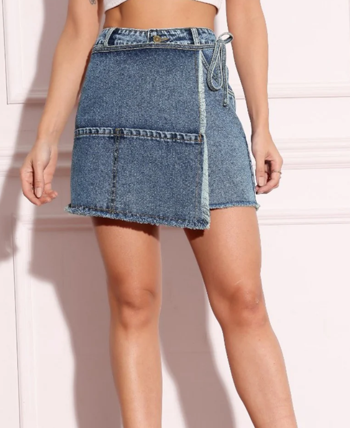 Denim skirt worn by a person on a white background