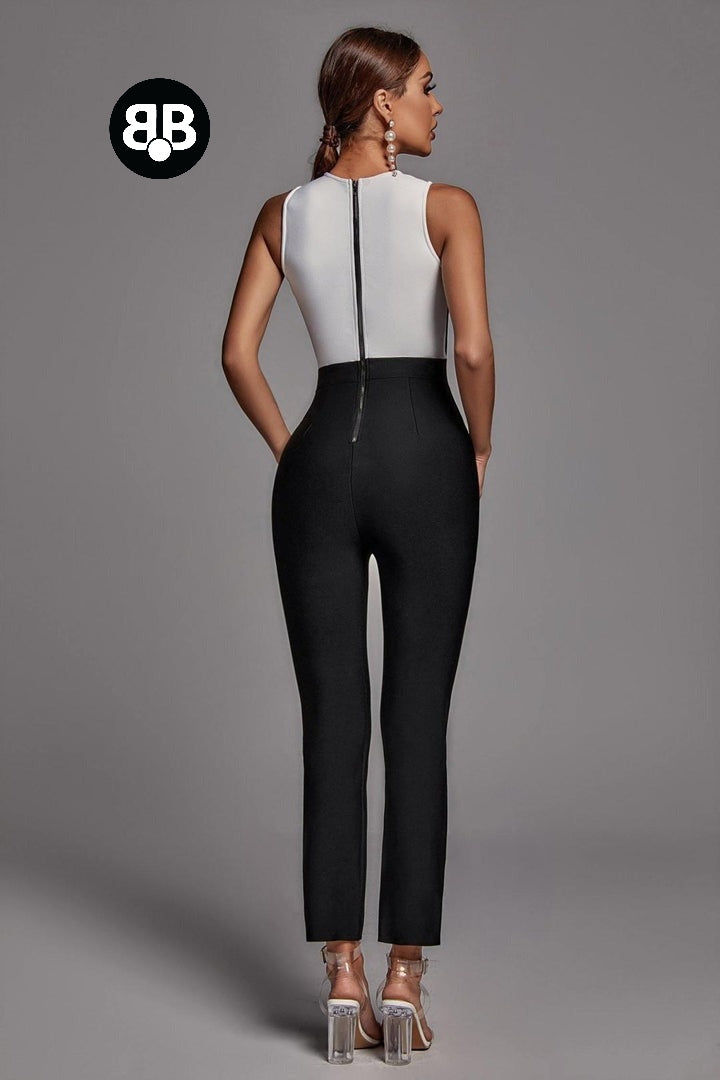 Woman wearing a black and white jumpsuit on a gray background with a brand logo.