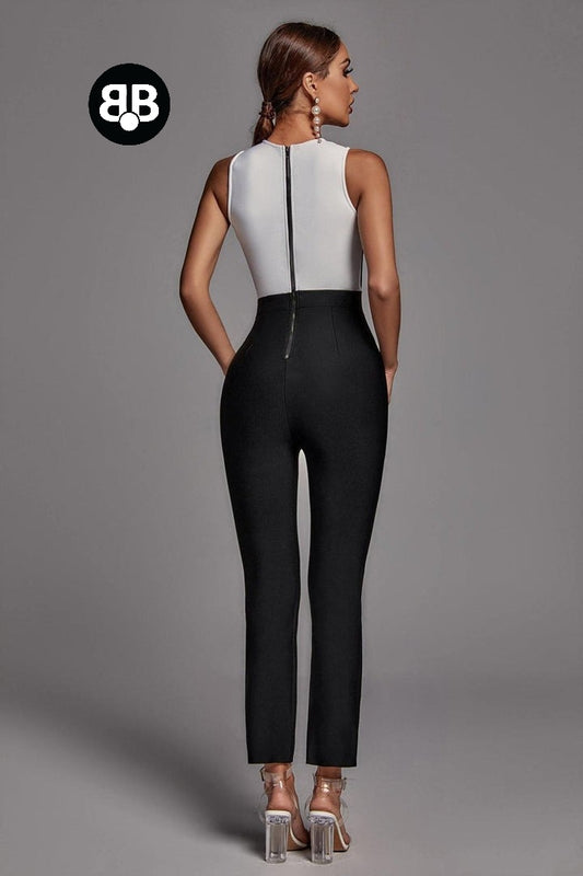 Woman wearing a black and white jumpsuit on a gray background with a brand logo.