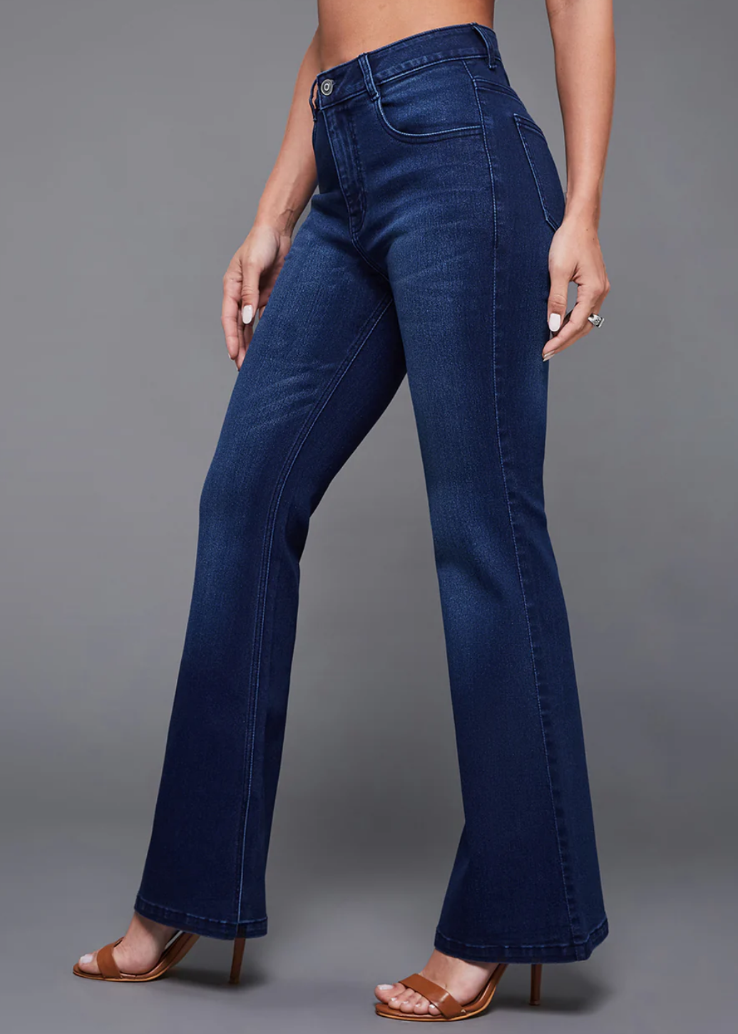 Person wearing blue jeans on a gray background