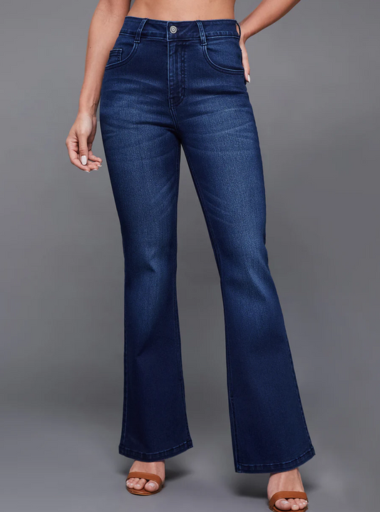 Person wearing blue flared jeans on a gray background