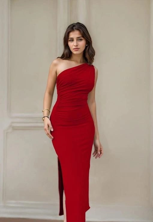 Woman wearing a red one-shoulder dress against a beige wall.