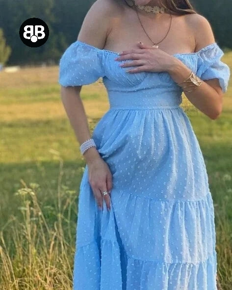 Woman wearing a light blue dress with polka dots in an outdoor setting