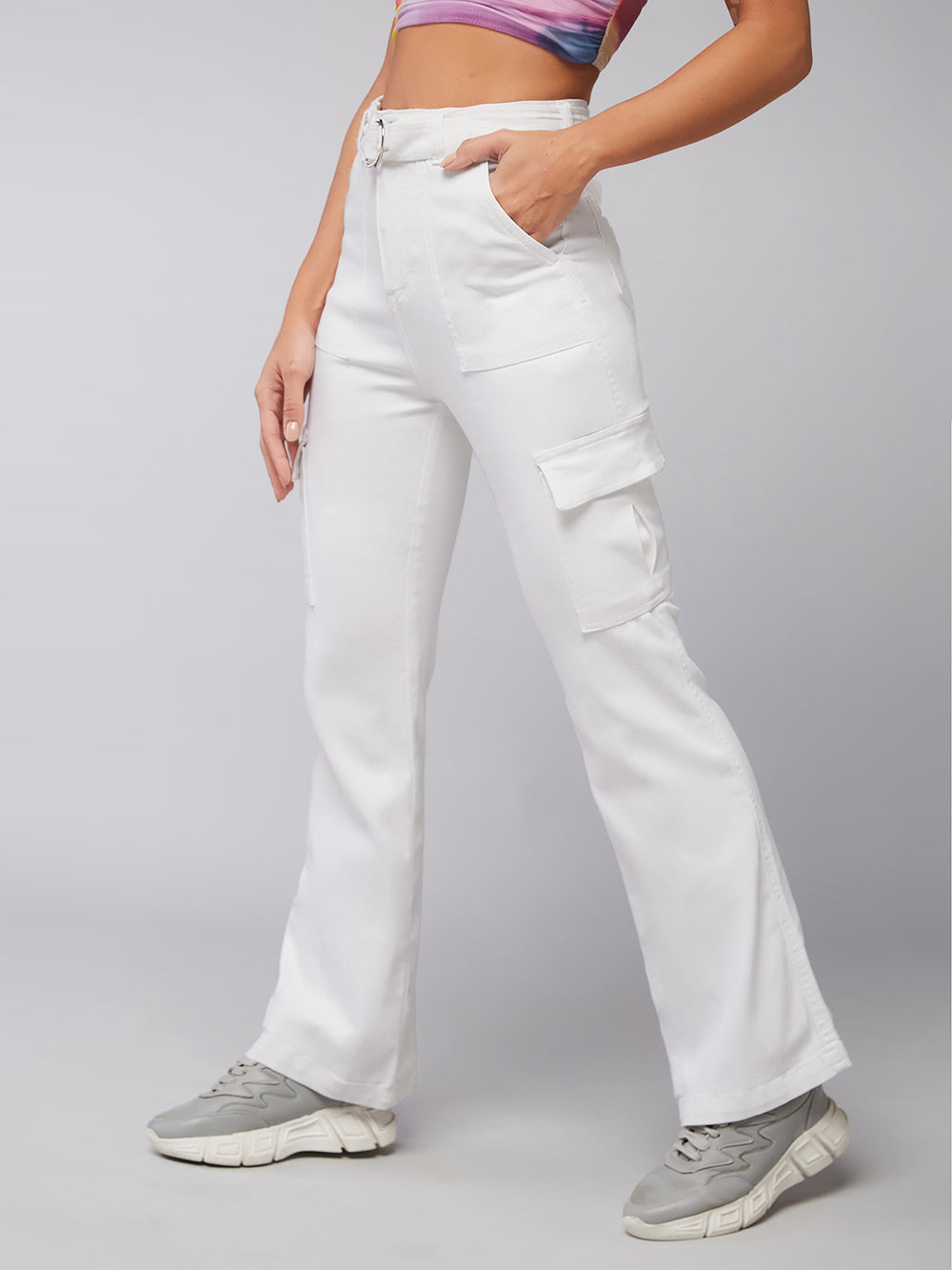 Person wearing white cargo pants on a plain background