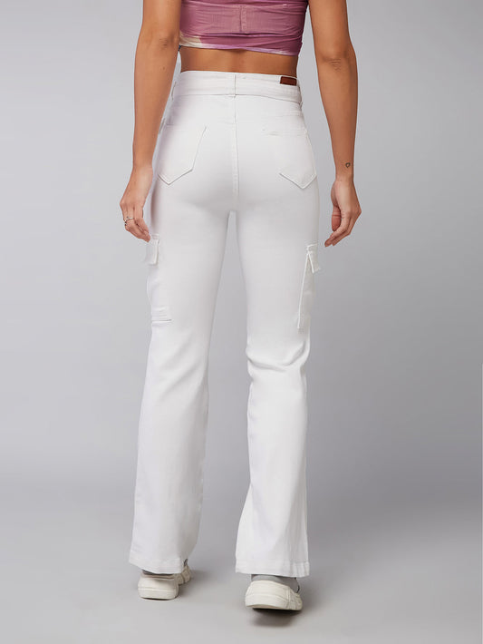 Person wearing white flared jeans on a plain background