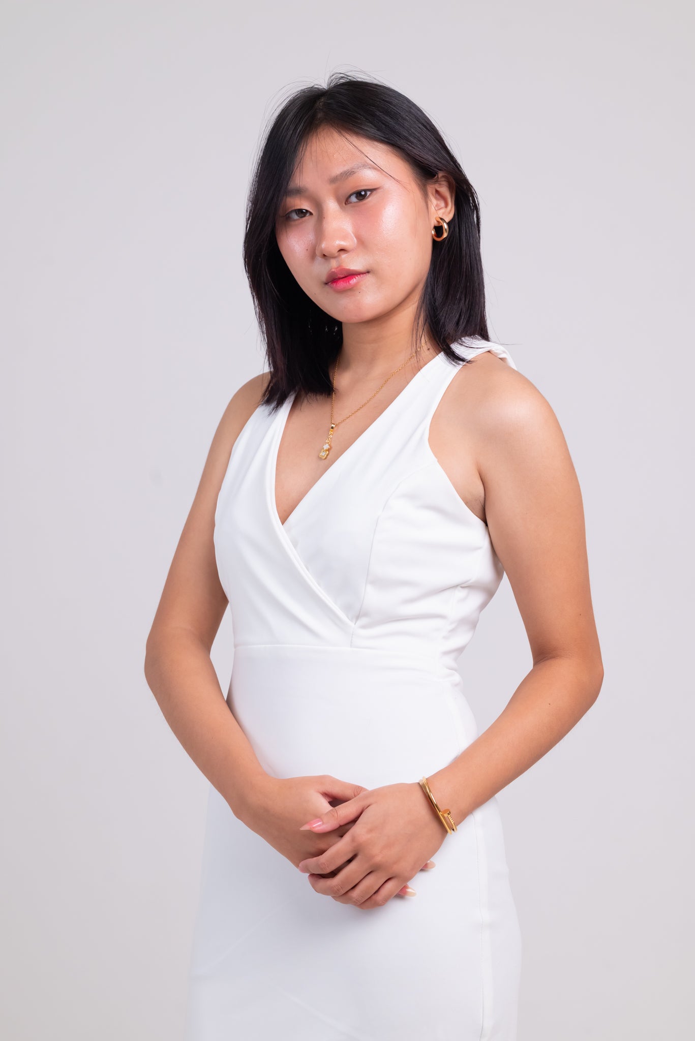 Woman wearing a white dress against a plain background