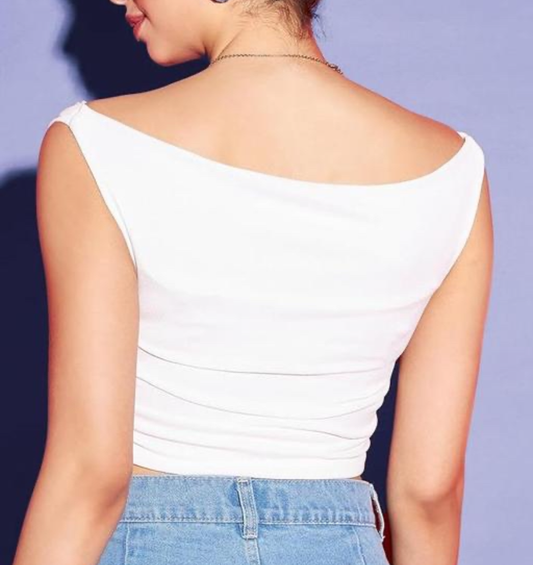 Person wearing a white sleeveless top and blue jeans against a purple background