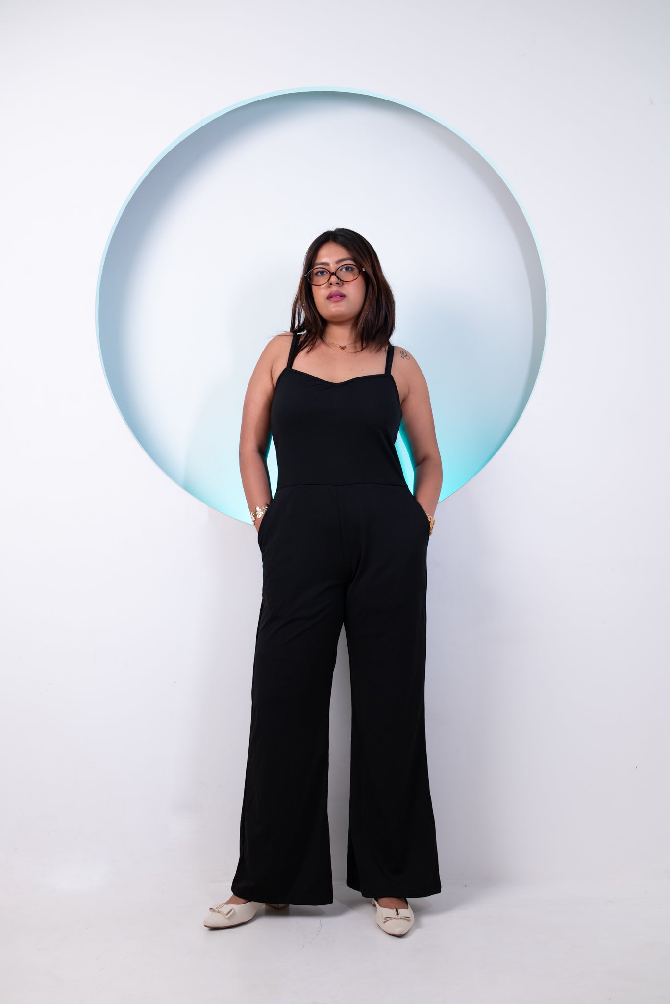 Person wearing a black jumpsuit standing in front of a large bubble on a white background