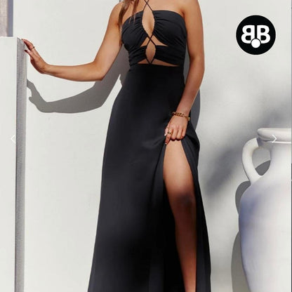 Woman wearing a black evening gown with a high slit, standing against a plain background.