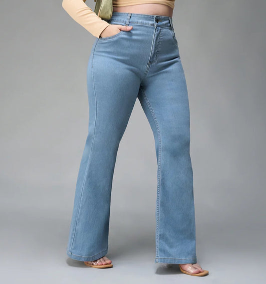 Person wearing blue flared jeans on a gray background