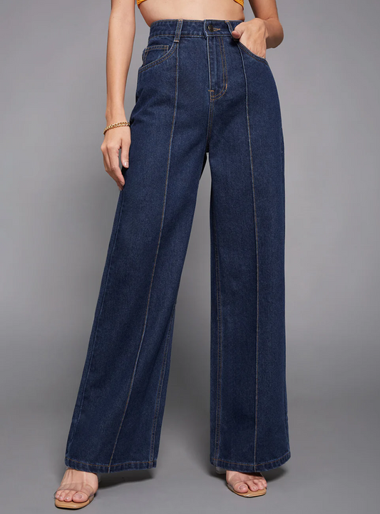 Person wearing blue wide-leg jeans on a gray background