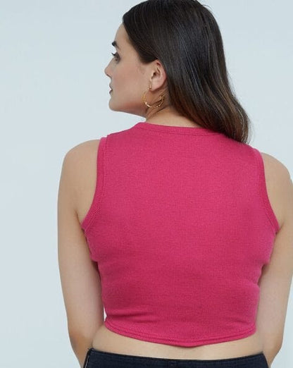 Woman wearing a pink sleeveless top against a plain background