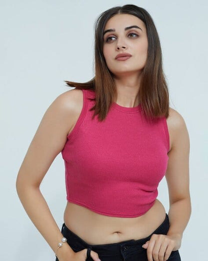 Woman wearing a pink sleeveless top against a plain background