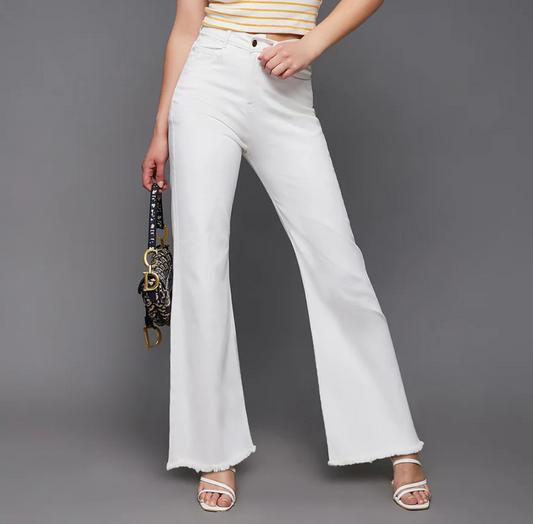 Person wearing white flared jeans on a gray background