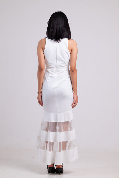 Woman wearing a white dress with sheer overlay on a plain background